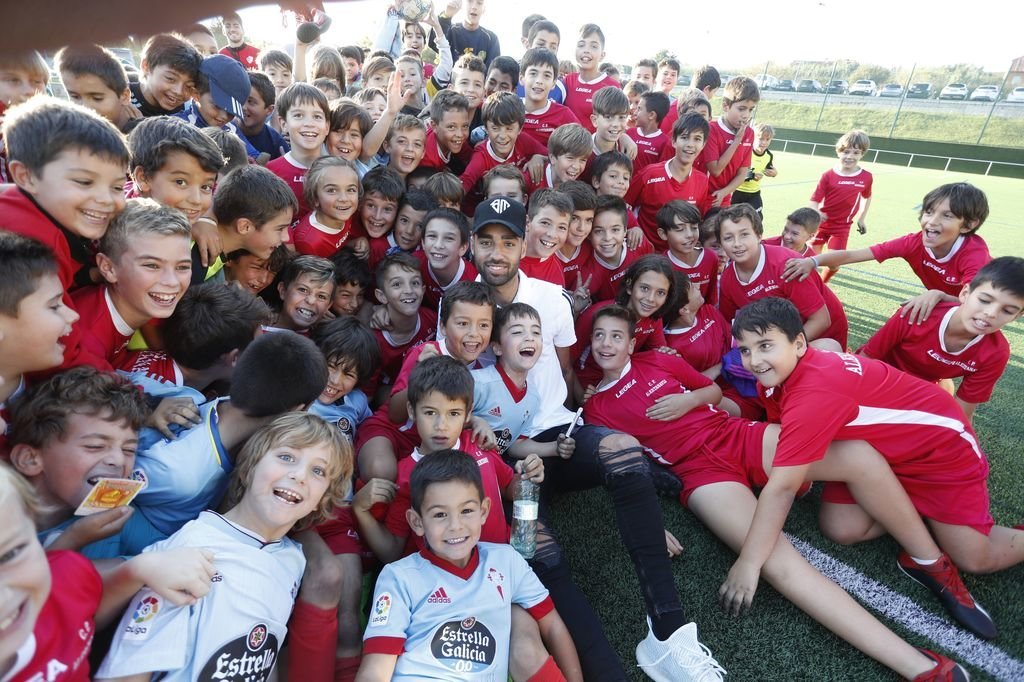 Brais Méndez, rodeado de niños en la visita realizada al campo de fútbol de Navia.