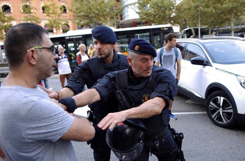 Un manifestante es deslojado de la calzada en las inmediaciones de la Plaza de España de Barcelona