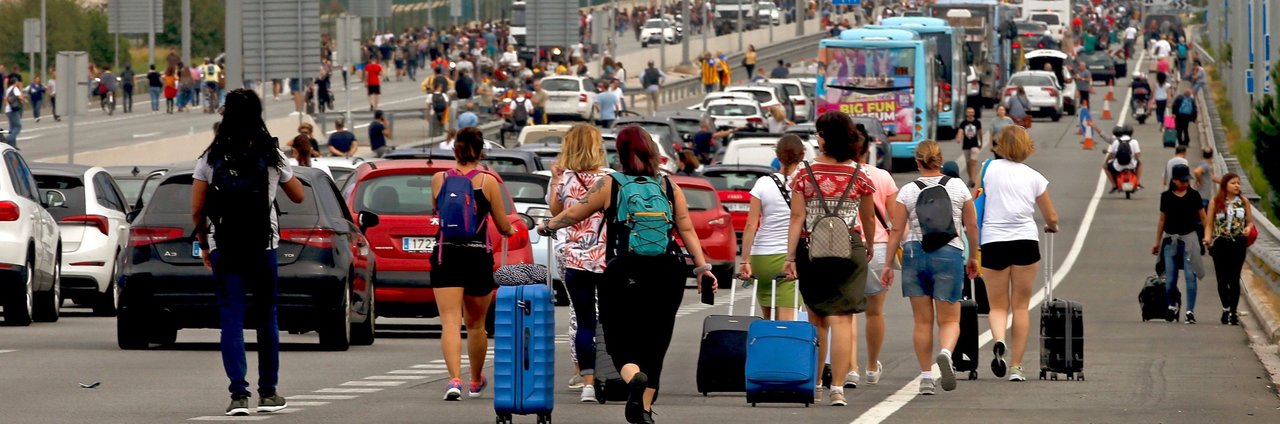 Varios viajeros llegan caminando al Aeropuerto del Prat después de que la plataforma Tsunami Democràtic haya llamado a paralizar la actividad del aeropuerto
