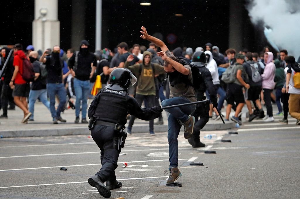 Un mosso carga contra un manifestante ante El Prat