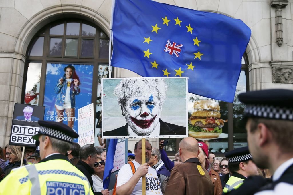 Manifestantes contrarios al &#34;brexit&#34; muestran carteles contra Boris Johnson.