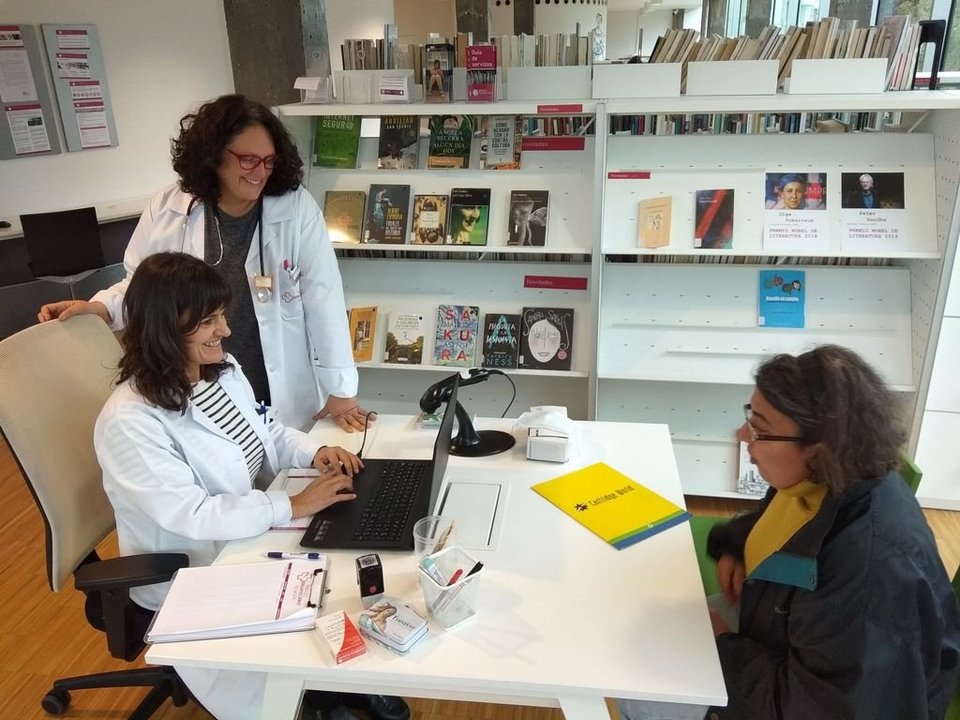 Las bibliotecarias pasan consulta a Consuelo Lemos, una usuaria habitual.