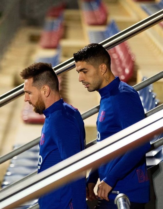 Leo Messi sale acompañado de Luis Suárez al entrenamiento de ayer.
