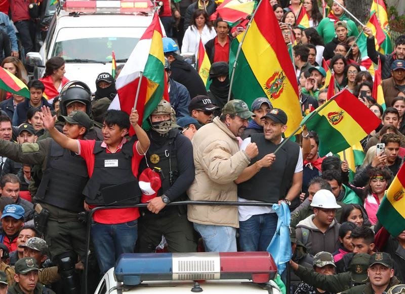 El líder cívico cruceño Luis Fernando Camacho (d) y el potosino Marco Pumari (i), celebran junto a ciudadanos bolivianos la renuncia del presidente de Bolivia, Evo Morales