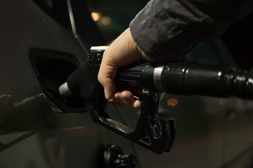 Un hombre reposta combustible para su automóvil en una estación de servicio