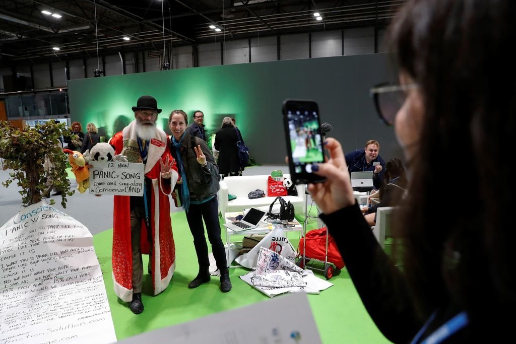 Una mujer se fotografía en la cumbre de Madrid junto al activista Philip McMaster, conocido como &#34;Sustaina Claus&#34;.