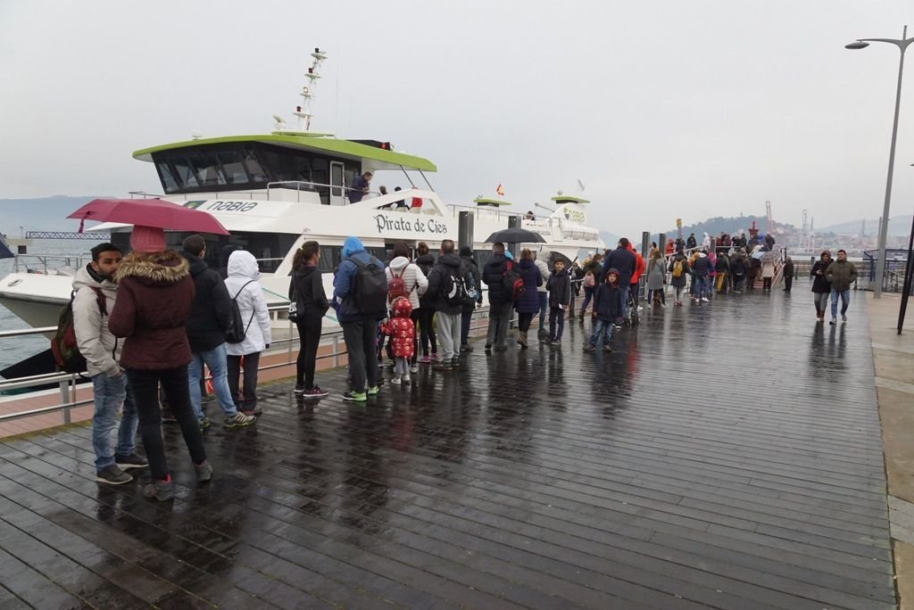 Colas para embarcar hacia Cíes ayer por la mañana, bajo la lluvia. Las dos navieras mantienen sus servicios en festivos, con el tope máximo de 450 viajeros.