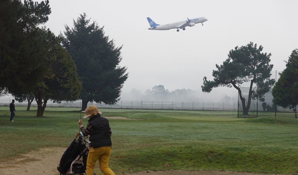 Una imagen única en el mundo: jugando ayer al golf en el campo instalado dentro del aeropuerto.