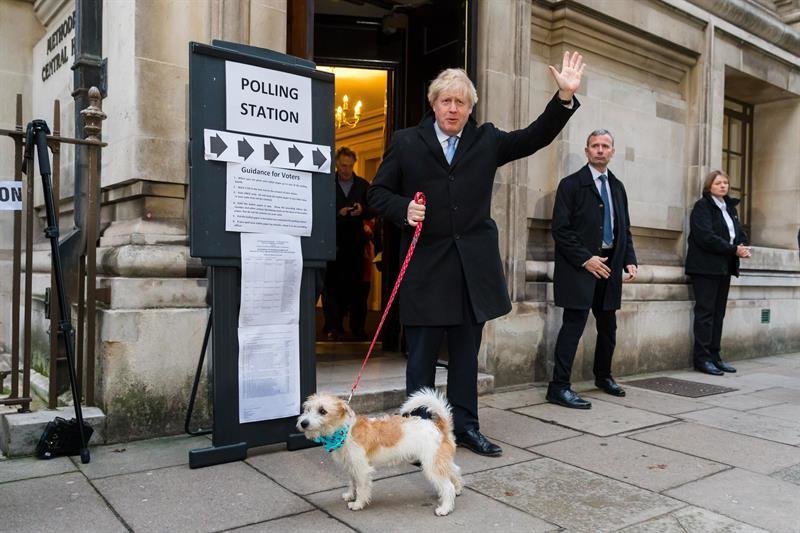 El Primer Ministro de Gran Bretaña, Boris Johnson (C), sale de un colegio electoral después de emitir su voto