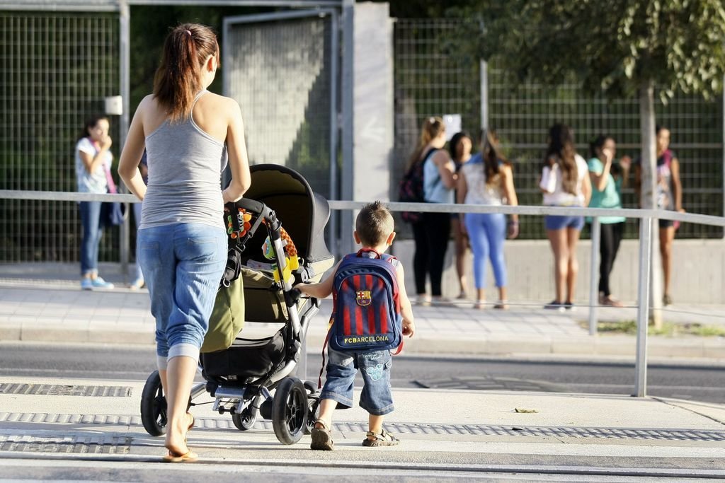 Una madre acompaña a su hijo en su primer día de colegio, en Alicante.
