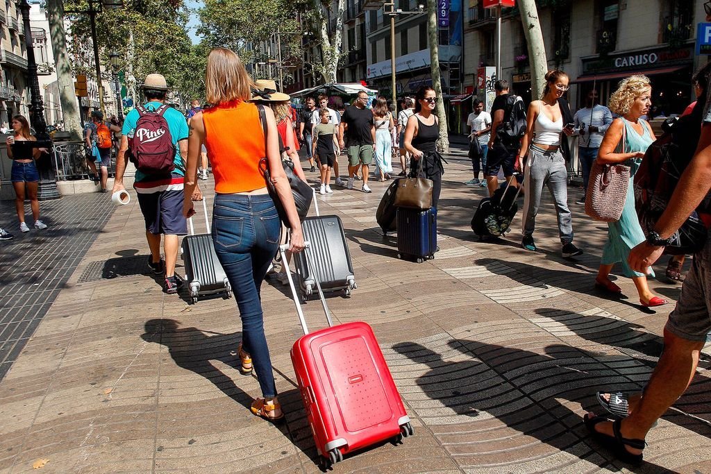 Grupos de turistas recién llegados a Barcelona pasean por las ramblas el pasado verano.