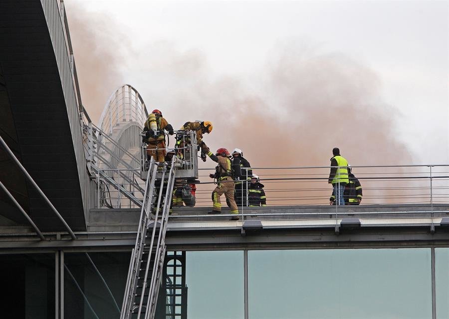 Un equipo de bomberos accede al techo del aeropuerto de Alicante-Elche para atajar el incendio en una de las cubiertas de la terminal de embarque