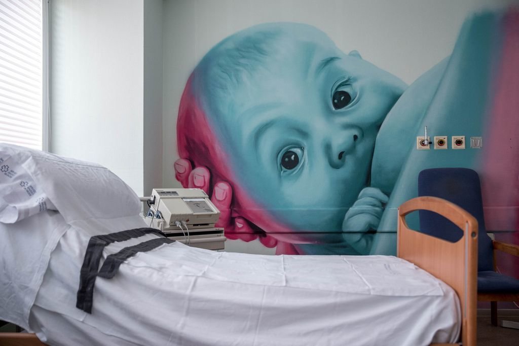 Una de las camas de la sección de Maternidad del Hospital de Verín, con un grafiti de Mon Devane en la pared.