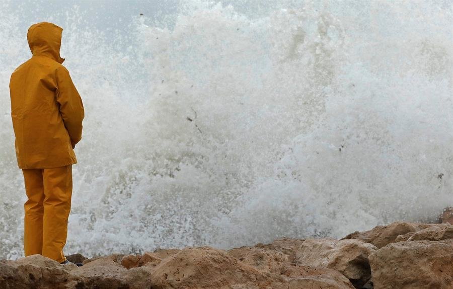 Un hombre observa las olas romper este lunes en el puerto deportivo de Denia