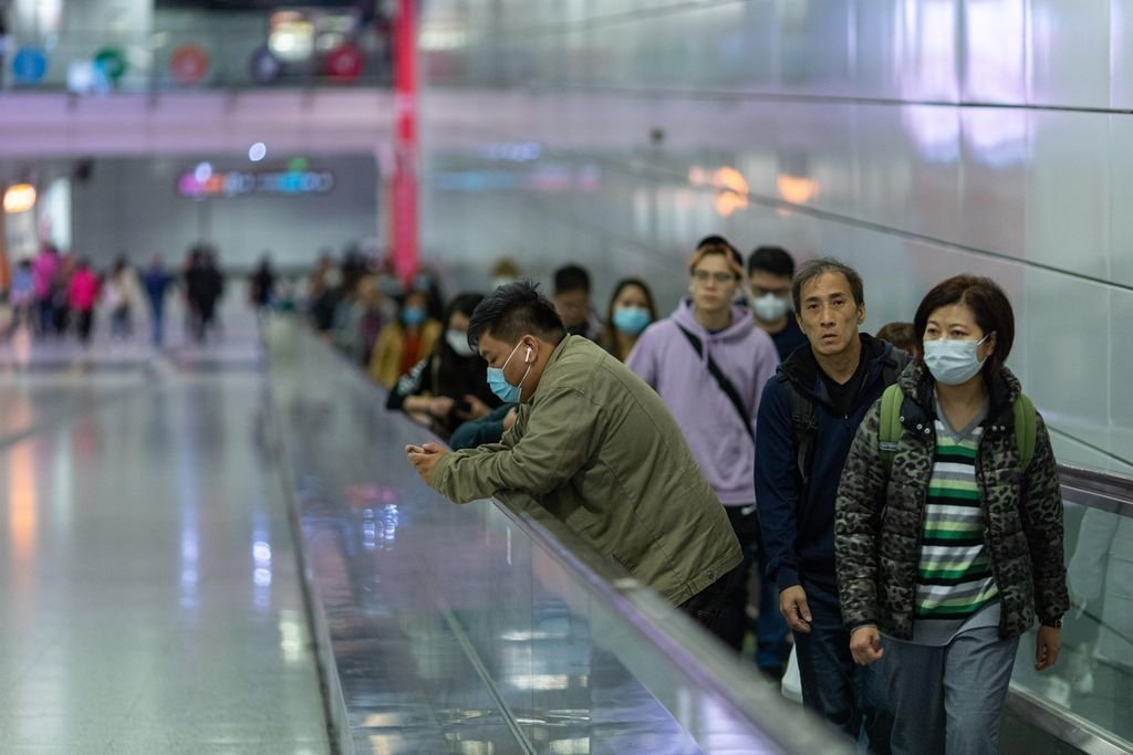 Usuarios del tren en Hong Kong se protegen ante la expansión del coronavirus.