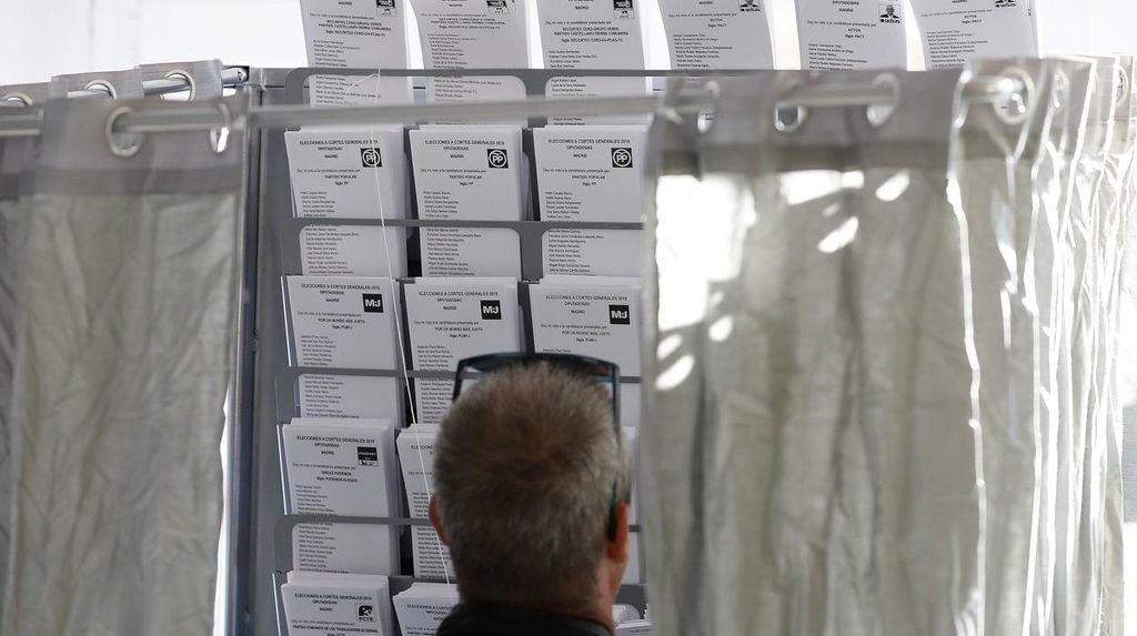 Un hombre observa las papeletas en un colegio electoral.