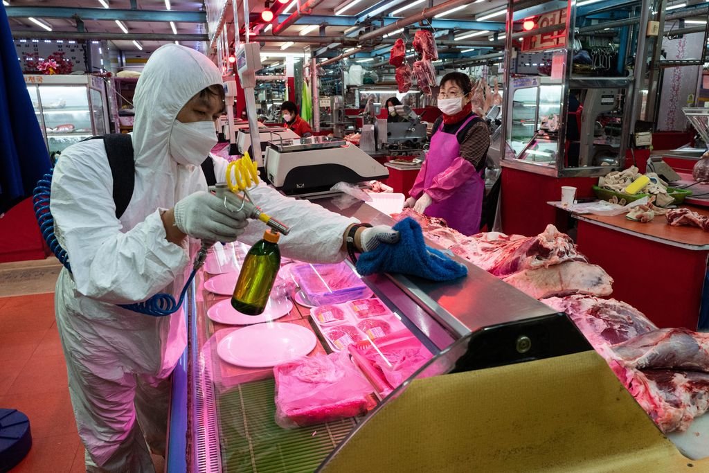 Un operario desinfecta un puesto de venta de alimentos en un mercado de Seul, en Corea del Sur.