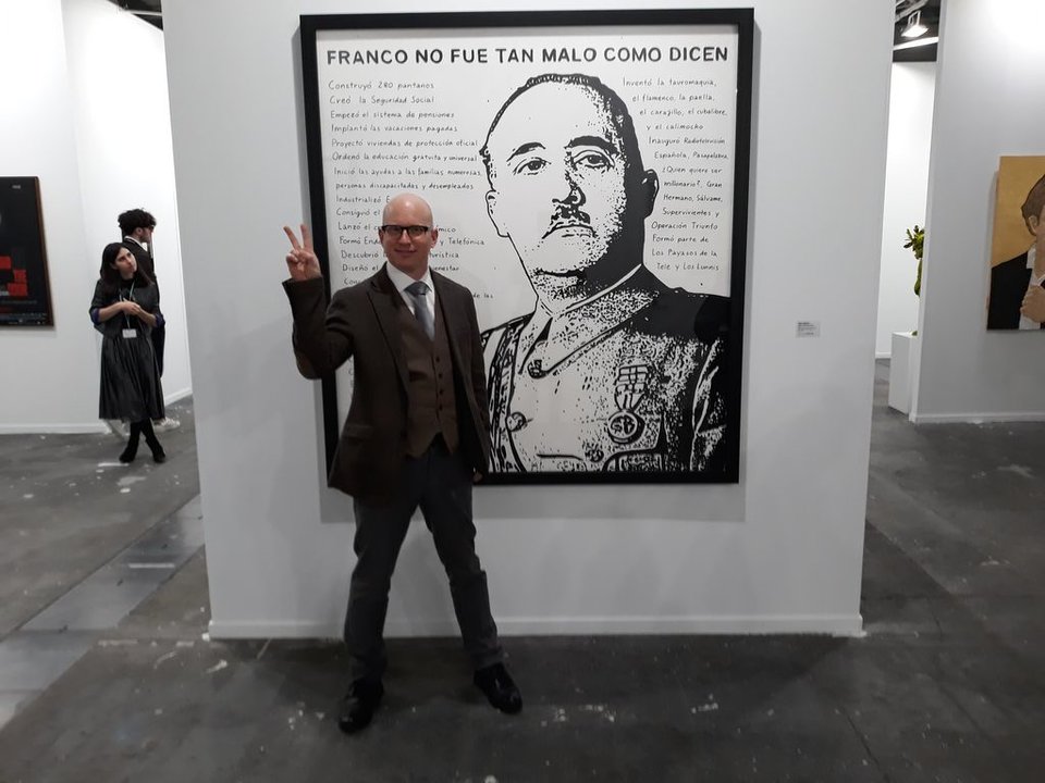 El artista finlandés Riiko Sakkinen afincado en España delante de su obra sobre Franco, que se expone en ARCO.