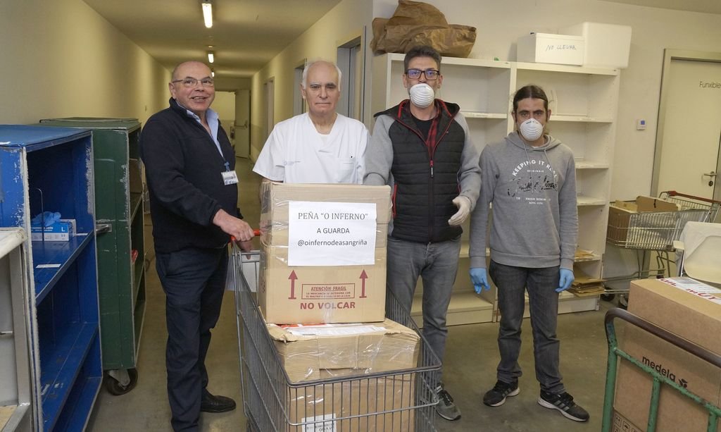 Dos representantes de la Peña O Inferno hacen la entrega del material donado a la dirección del hospital Álvaro Cunqueiro.