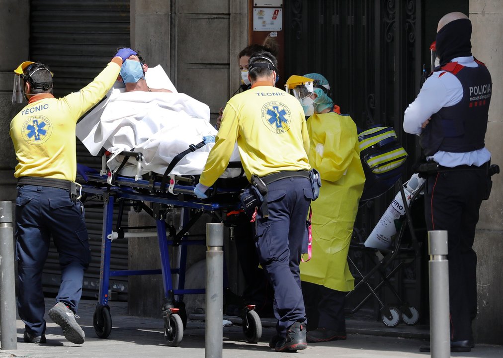 Un joven con sintomas de COVID-19 es trasladado por una ambulancia en el centro de Barcelona