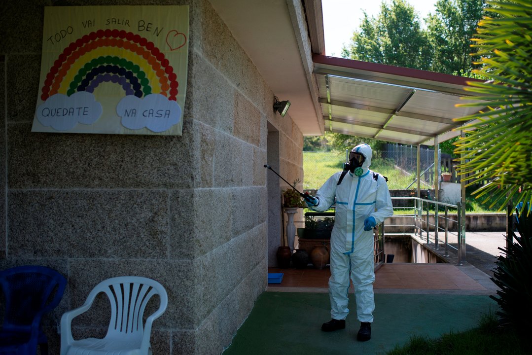 Un voluntario del servicio de prevención y defensa contra los incendios forestales realiza labores de desinfección en un geriátrico de Amoeiro en Ourense