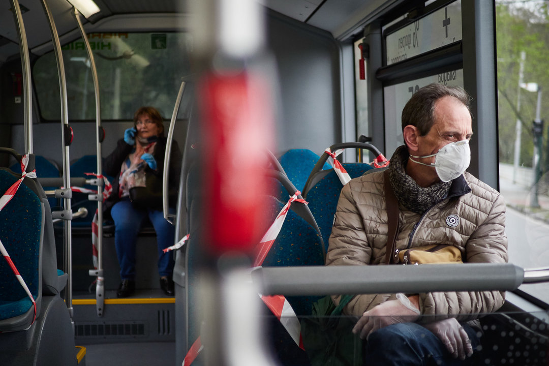 Un hombre protegido con una mascarilla viaja en un autobús urbano