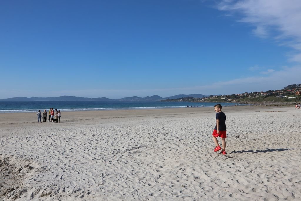 Grupo de personas paseando por la playa de Patos, ayer.