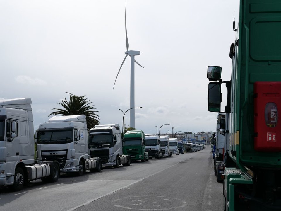 Camiones en el polígono de Sabón, con el molino eólico de Inditex al fondo.