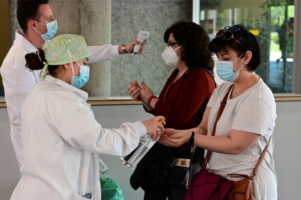 Dos sanitarios toman la temperatura a dos pacientes del Hospital de Alcorcón.