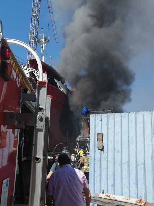 Los bomberos sofocando ayer el incendio en el astillero de Moaña.