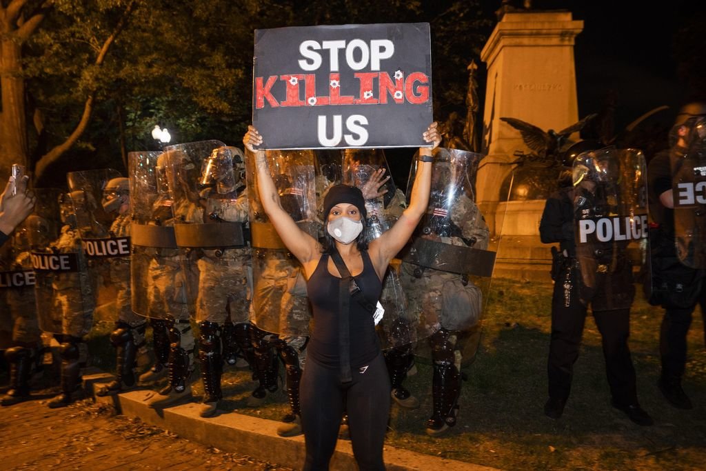 Una manifestante muestra un cartel de protesta ante uno de los cordones policiales en Washington.