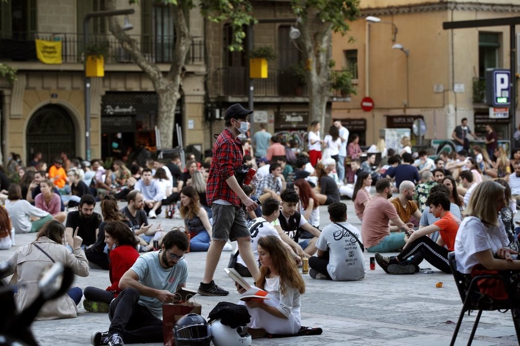Reunión de jóvenes en una plaza de Barcelona para celebrar el pase de fase en la ciudad.