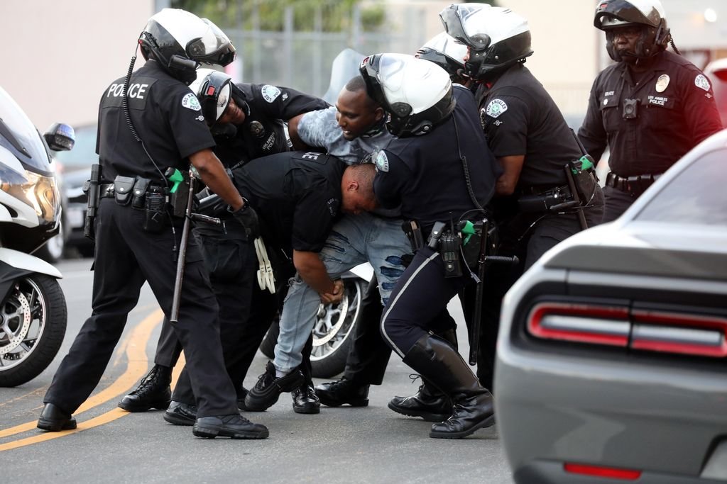 Un grupo de policías de Hollywood se esfuerza para detener a un hombre que circulaba en su vehículo durante el toque de queda.