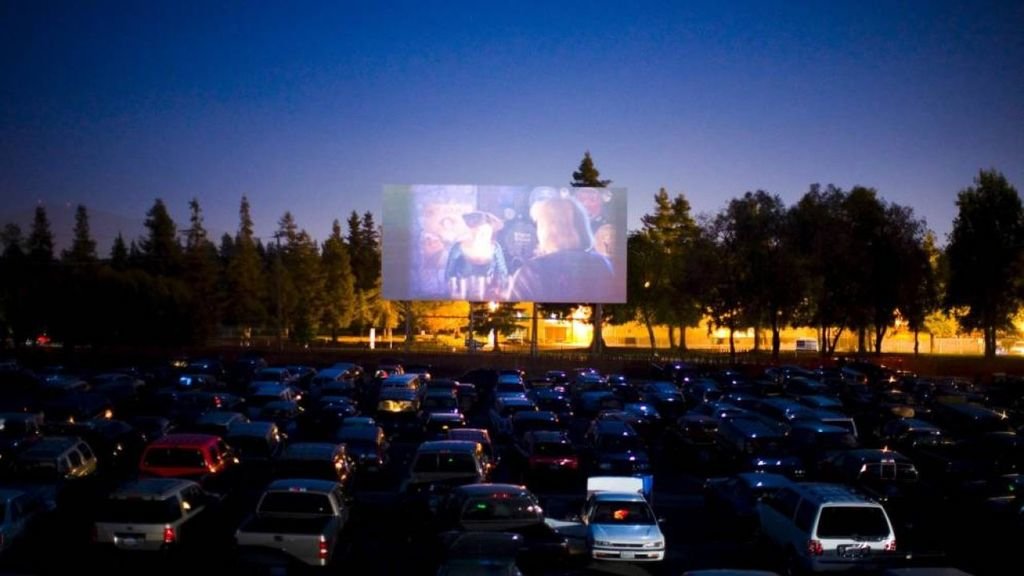 Un autocine de las afueras de Madrid proyecta una película ante varios coches.