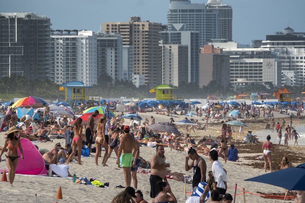 Cientos de personas abarrotan una playa de Miami sin medidas de protección frente al covid-19.