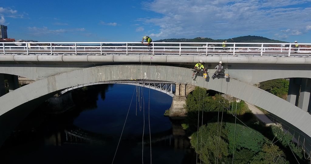 Operarios especializados en trabajos de altura, dan un repaso al sólido hormigón del viaducto