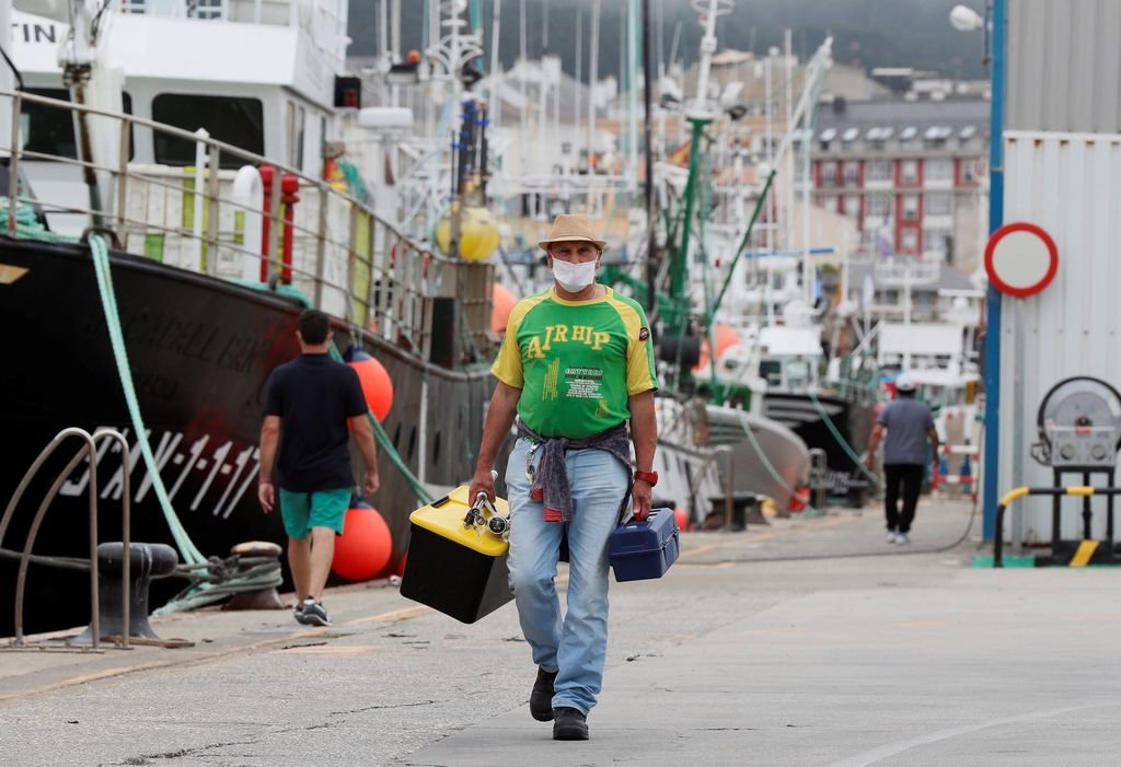 Un pescador camina con parte de su material en el puerto de Burela, después de decretarse el cierre.