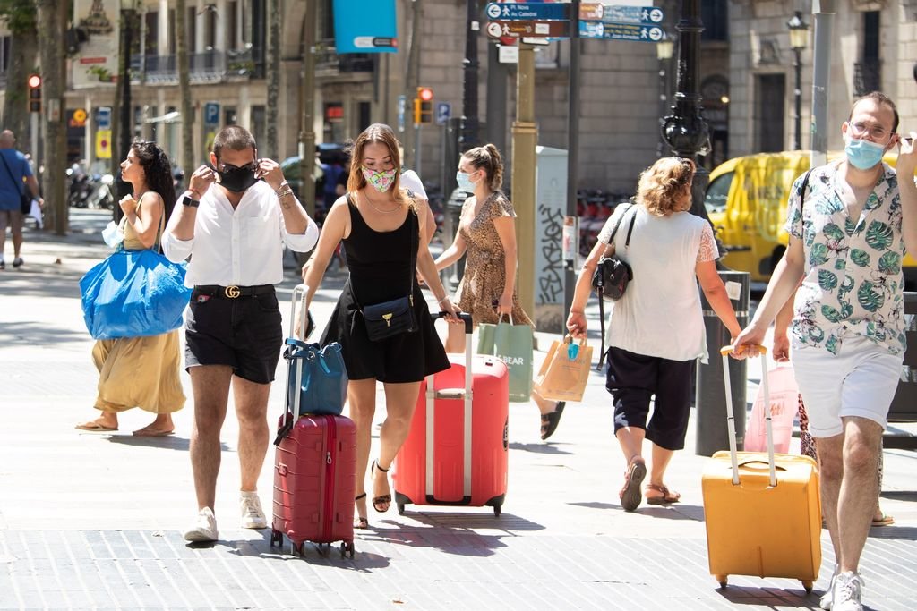 Un grupo de turistas recién llegados a la ciudad, con mascarilla por la Rambla de Barcelona.