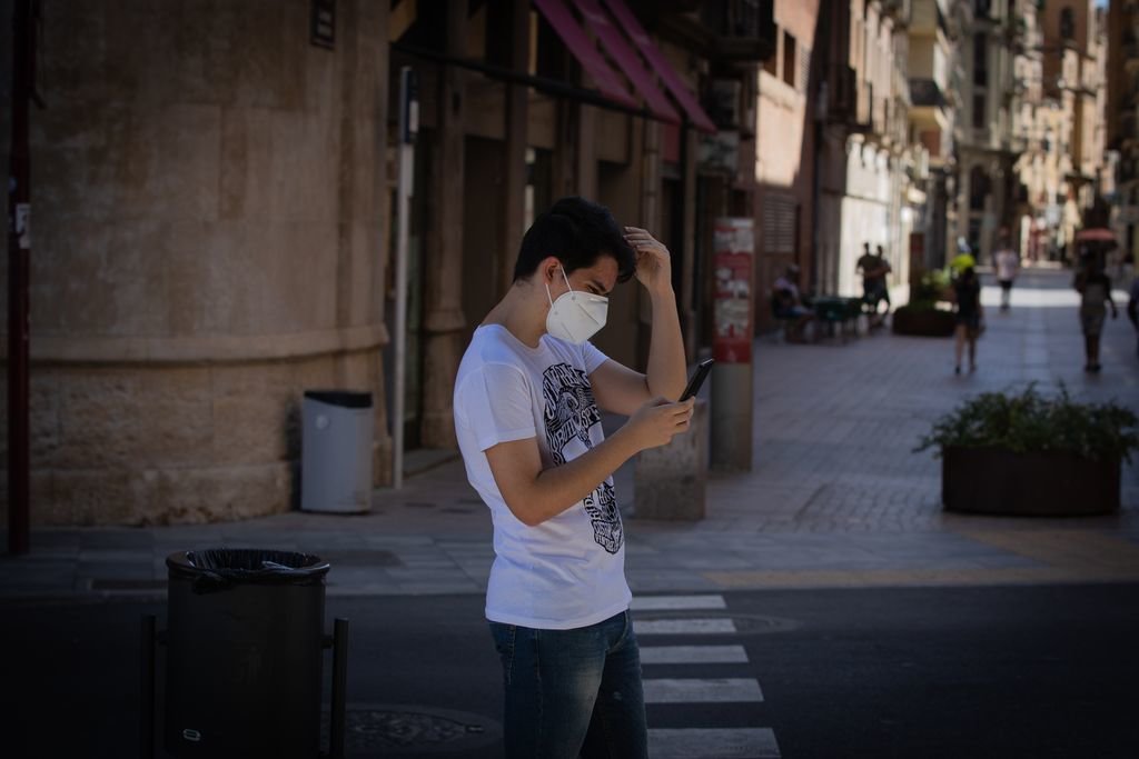 Un joven protegido con mascarilla camina por una calle del centro de Lleida.