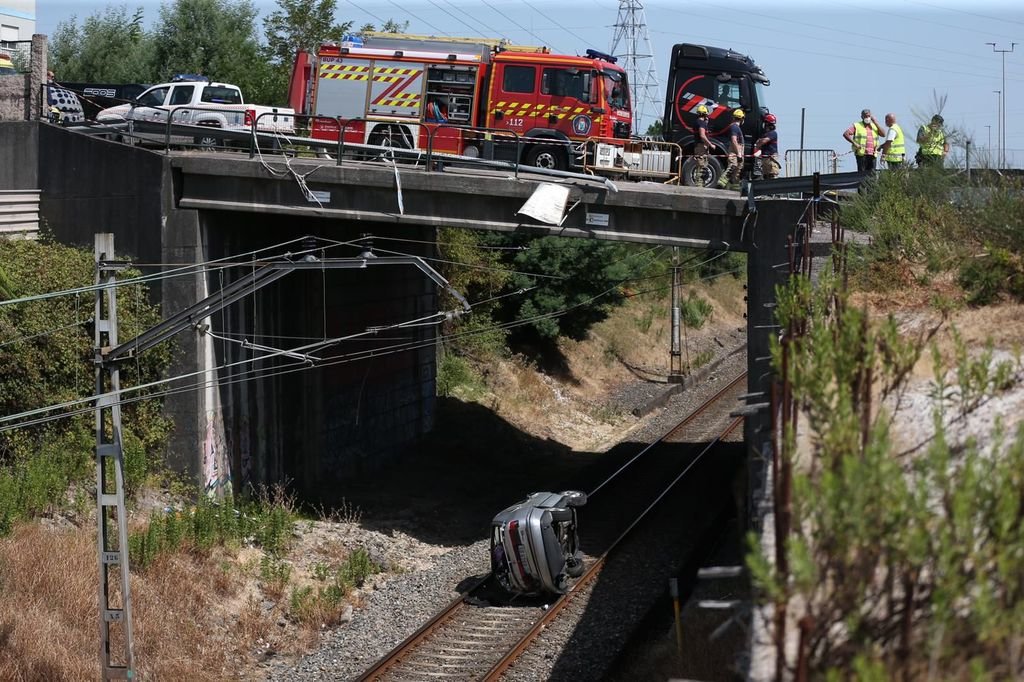 El vehículo, tras desplomarse desde el puente. Mientras tanto, la vía de Vigo a Porriño estuvo cortada.