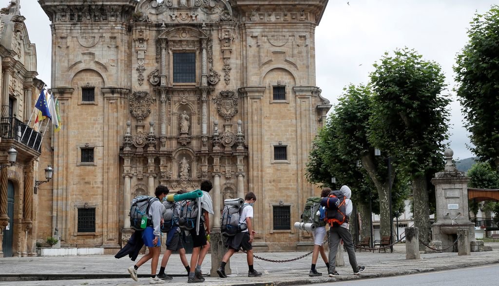 Un grupo de peregrinos pasa ante el monasterio de San Salvador, en Lourenzana (Lugo).