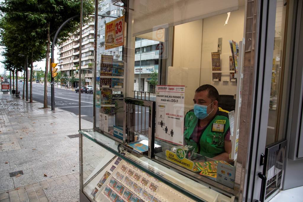 Un vendedor de lotería, al frente de su puesto en una avenida de Cataluña.