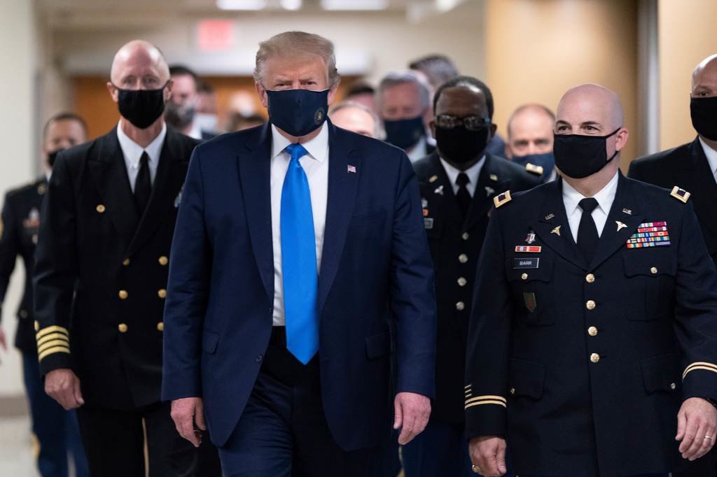 Trump, con  máscara, acompañado por un grupo de militares en Bethesda, Maryland.