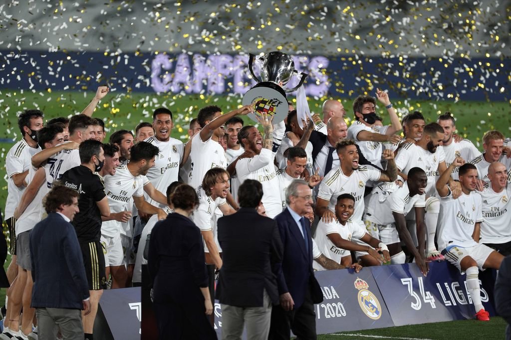 Los jugadores del Real Madrid, con Ramos a la cabeza, levantan el trofeo que les acredita como campeones de liga.