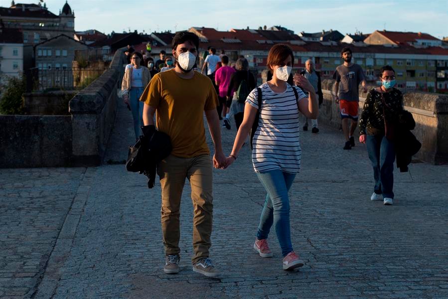 Varias personas pasean por el Puente Romano de Ourense.