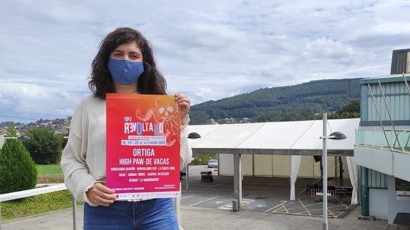 Sara Alonso muestra el cartel de Revoltallo, delante del recinto cubierto donde se celebra el festival.