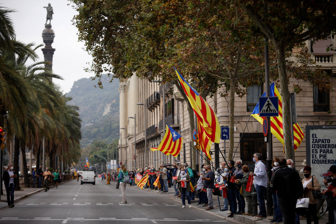 Manifestantes sostienen banderas independentistas en la cadena humana formada como signo de protesta por la visita del Rey a Barcelona