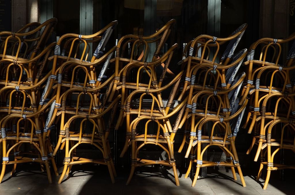 Las sillas de la terraza de un bar de Barcelona, apiladas tras el cierre decretado por la Generalitat.
