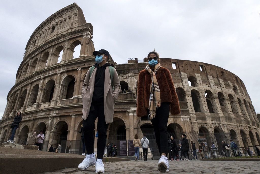 Un grupo de turistas pasea por las inmediaciones del Coliseo de Roma, Italia.