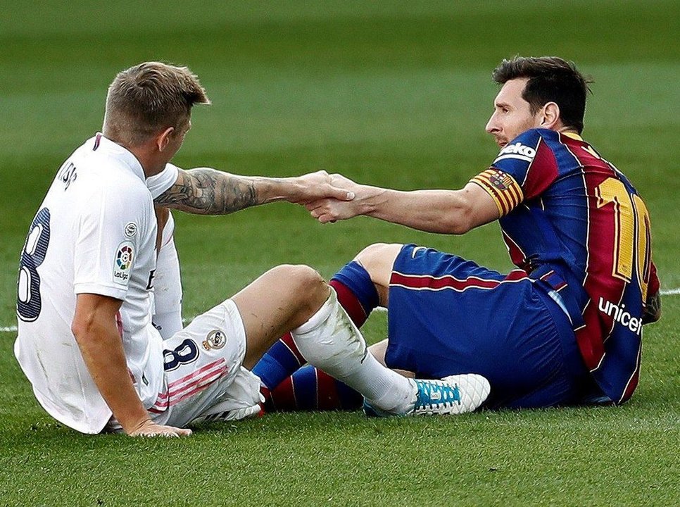 El madridista Toni Kroos ayuda a levantarse al barcelonista Leo Messi en un momento del partido vivido ayer tarde en el Camp Nou.